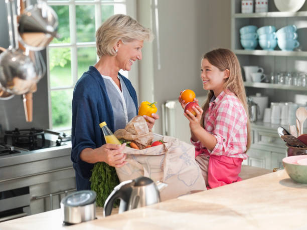 istock Woman and granddaughter unloading groceries 164853476