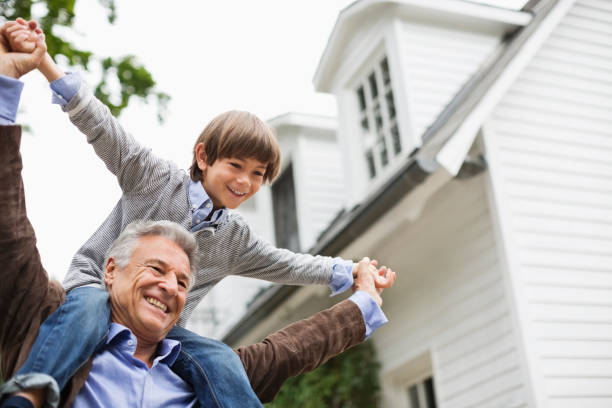 Man carrying grandson on shoulders outdoors  old building stock pictures, royalty-free photos & images