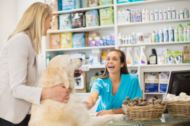 Receptionist greeting dog in vet's surgery  veterinary surgery stock pictures, royalty-free photos & images