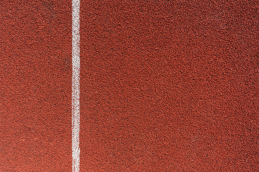 Running track surface with lanes and lines on a track and field athletics stadium. Sport running, jogging or walking runway.