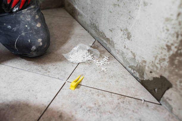 istock Fine precise accurate work of a tiler when laying tiles on the floor 1648545432