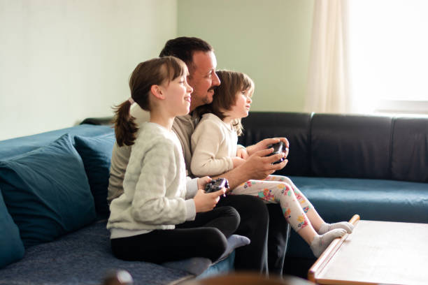 istock Father playing play station whit his daughters at home 1648625339