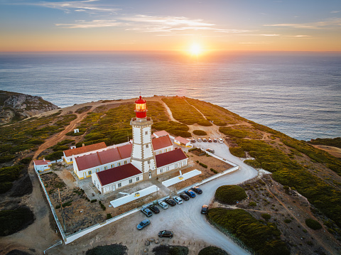 Aerial drone view of lighthouse on Cabo Espichel cape Espichel on Atlantic ocean at sunset. Sesimbra, Portugal