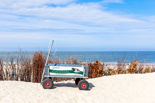 Spiekeroog, Germany, August, 23, 2023 - Handcart for luggage of tourists on a sand dune, North Sea island Spiekeroog