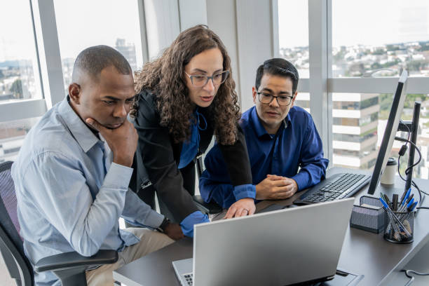 Cybersecurity team discussing in front of a monitor screen