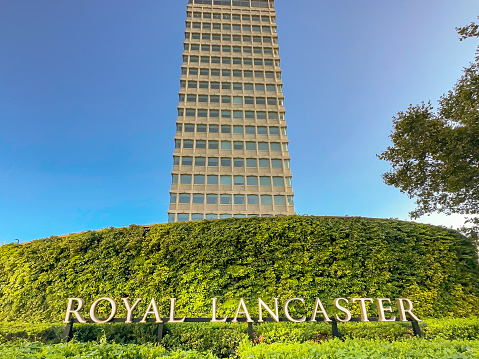 London, England, UK - 22 August 2023: Wide angle view of a sign in the garden outside the Royal Lancaster Hotel in Lancaster Gate in west London. The hotel building is in the background