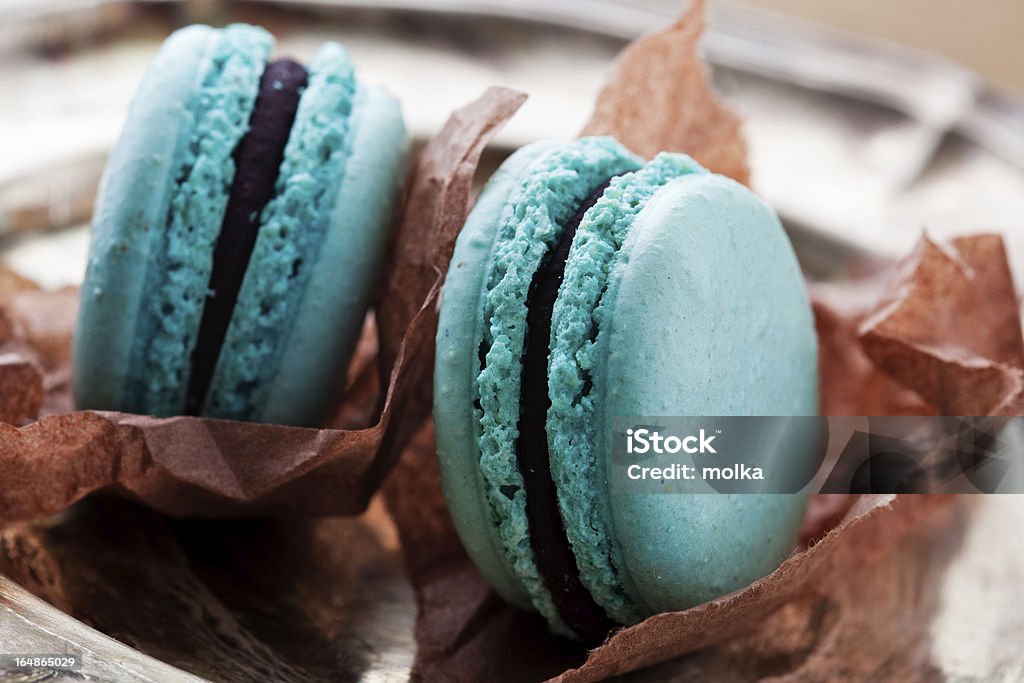 French macaroons Turquoise french macaroons on dark wooden background Baked Stock Photo