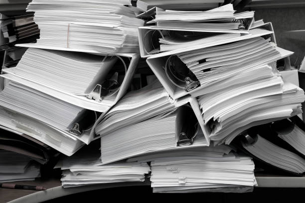 istock Messy Office Pile of Binders with Papers Filing Disorganized Mess 1648662367