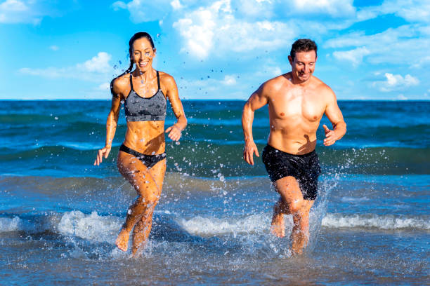 istock Run fit people running on beach with healthy toned legs body, Hamstring muscles 1648674257
