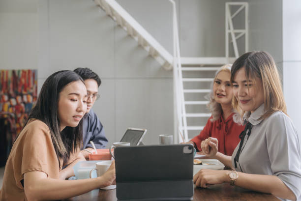 istock Asian woman using tablet for discussion for work with friend while having lunch at office 1648716251