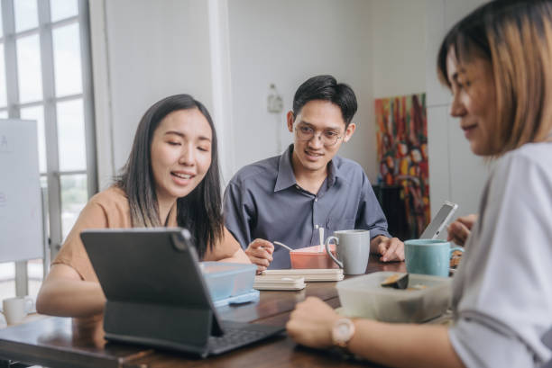 istock Group of colleague using tablet for work and talking with friend about project during having lunch. 1648716302