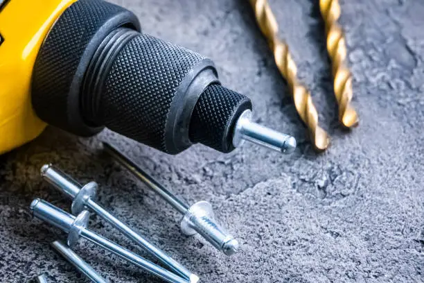 Riveter with rivets and drill bits on a table