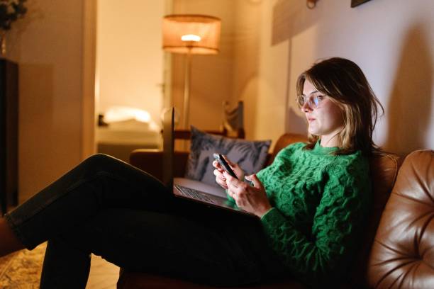 istock Beautiful woman looking at a smartphone while working from home 1648735969