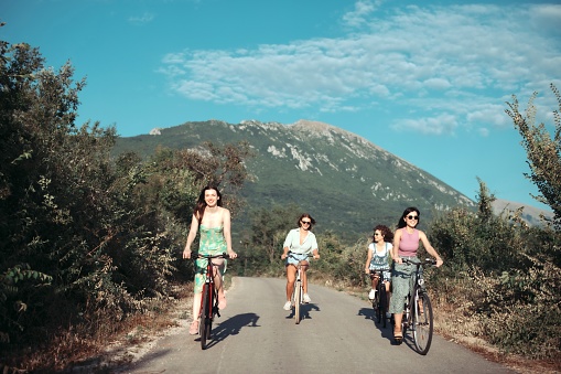 Athletic young woman rides a bike in a mountainous area in the forest, copy space.