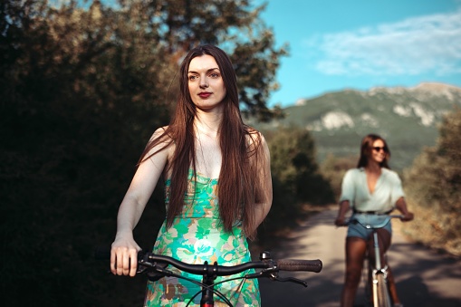 Close-up of a beautiful girl riding a bike with her friends in the nature