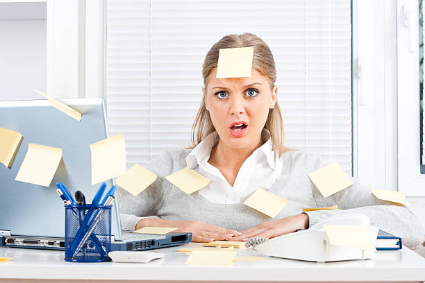 istock An overworked woman with sticky notes all over her and desk 164874519