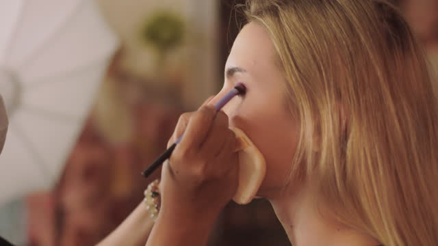 Portrait of girl in makeup studio,Girl make-up artist applies makeup,Beauty concept.