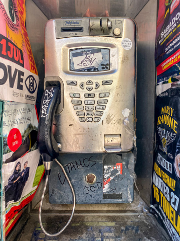 Valencia, Spain - August 19, 2023: Old phone booth out of order. With the widespread use of the smartphones almost by every person these became obsolete and now are used as billboards