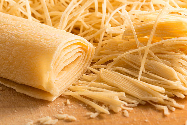 Hand-cut noodles on wooden cutting board stock photo