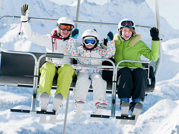 istock People vacationing and riding on ski lift 164877796