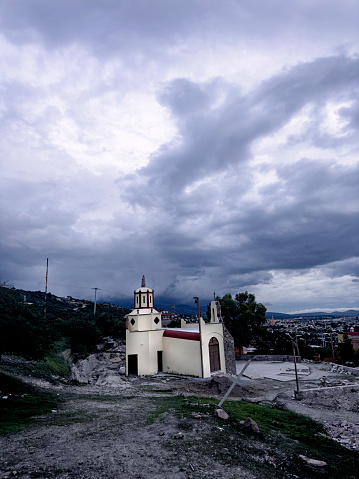 A small local church, still having construction done, under a moody dramatic sky