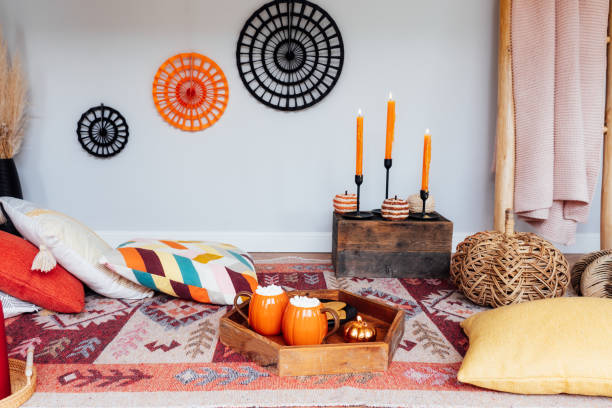 istock Decorated cozy autumn interior for relax during fall holidays. Comfy floor location with cushions, wicker pumpkins, burning candles. Thanksgiving, Halloween plans at home. Romantic date, movie night. 1648794877