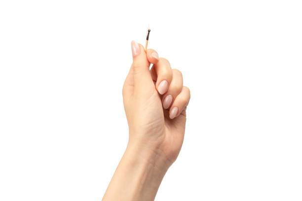 istock Lit match in a woman hand isolated on a white background. 1648799213
