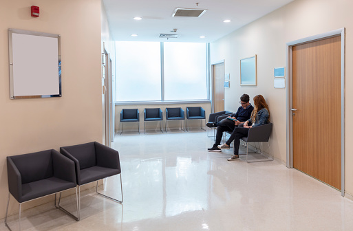Hospital Waiting Room. Male and female patients waiting in the waiting room. Modern hospital.