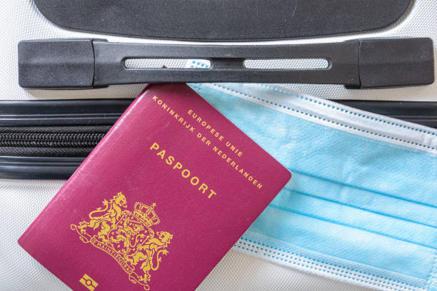 istock mouth mask and passport on a suitcase 1648886198