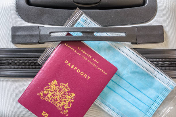 istock mouth mask and passport on a suitcase 1648886450