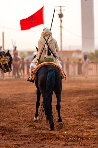 Essaouira, Morocco - 13 August 2023 : Equestrians participating in a traditional fancy dress event named Tbourida in Arabic dressed in a traditional Moroccan outfit and accessories of the knights