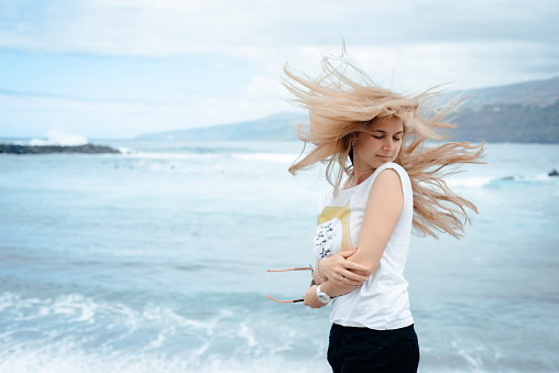 A beautiful woman stands on a pier on the embankment in Georgia by the beautiful sea