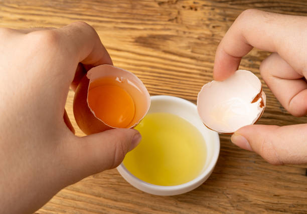 istock Broken Egg in Hand, Raw Yolk and White Separation, Cracked Brown Shell, Fresh Broken Organic Chicken Eggs 1648910554