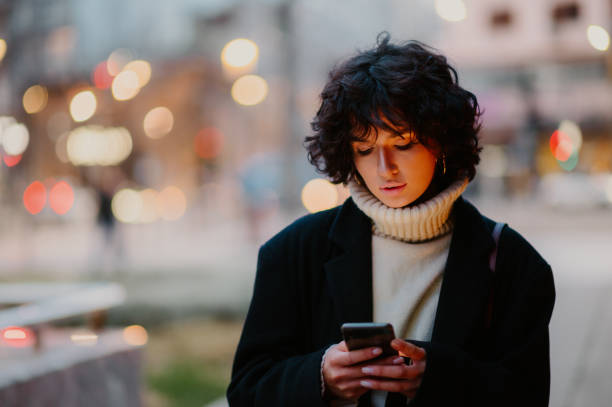 istock Beautiful woman looking down while typing a text message on her smart phone. 1648941030