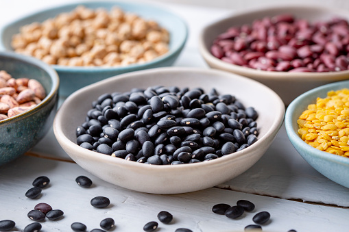Different types of legumes in bowls - black beans