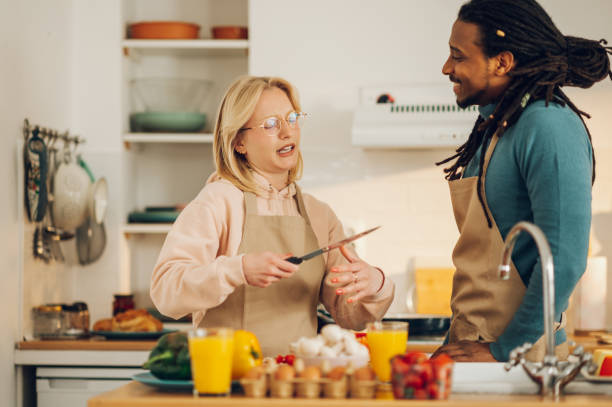 istock An interracial couple is cooking a meal while talking in the kitchen. 1648948048