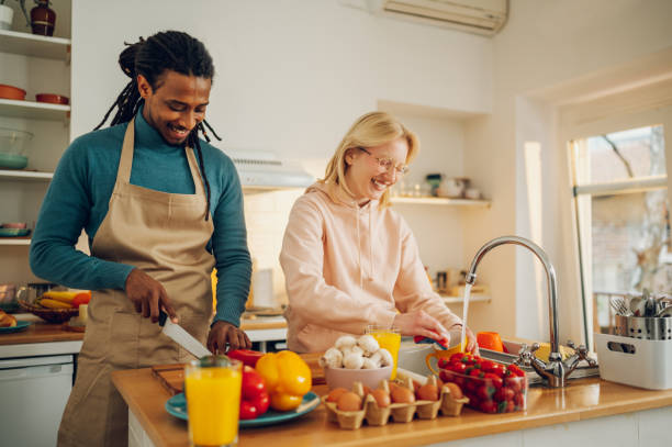istock A cheerful multiracial couple is standing in a kitchen and preparing lunch and doing dishes together. 1648948477