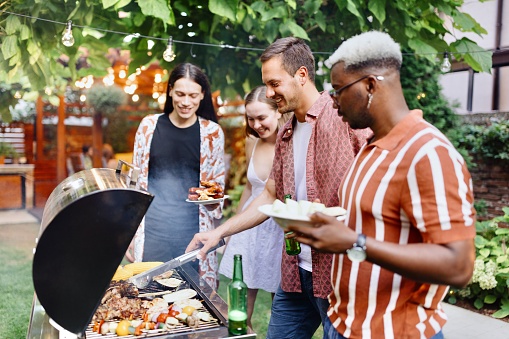 Beautiful group of people preparing a barbecue in the backyard
