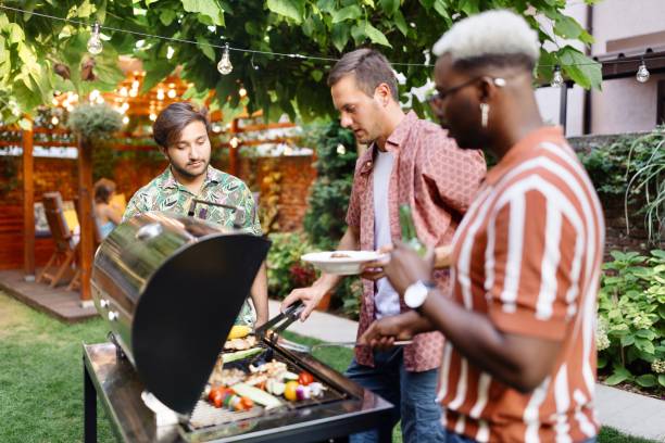 istock Multiracial men talking and preparing some food on the grill 1648951913