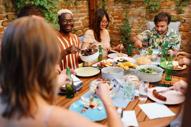 istock Multiracial people sitting at the table and eating some food 1648960048