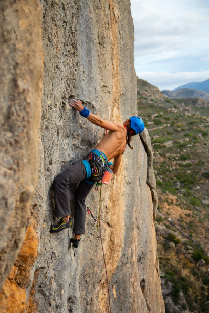 istock Shirtless climber man climbing mountain wall on amazing sunny day 1648971941