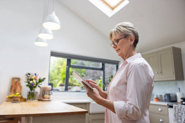 istock Mature woman at home using a digital tablet 1649042186