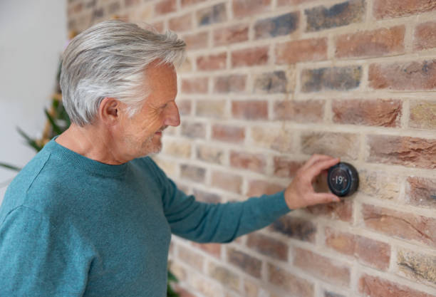 istock Senior man adjusting the temperature of his smart home 1649042702
