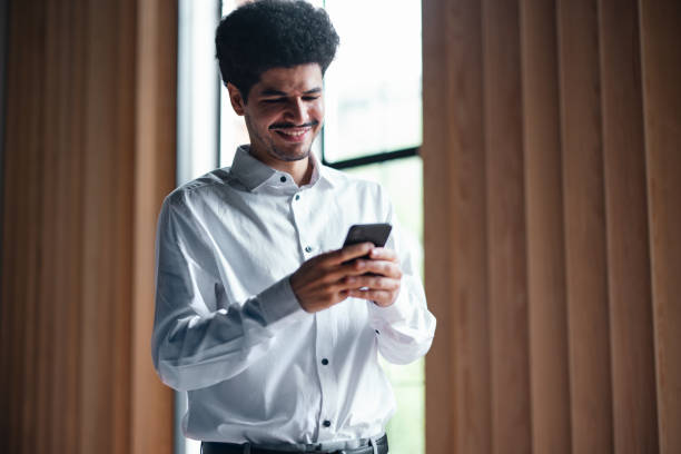 istock A Happy Handsome Businessman Texting On His Mobile Phone 1649044972