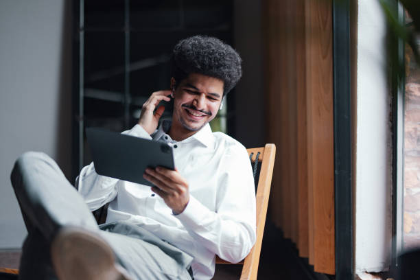 istock A Happy Handsome Businessman With Earbuds Watching Something On His Tablet While Relaxing In The Office 1649045002