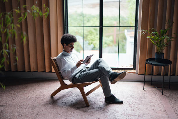 istock A Happy Handsome Businessman With Earbuds Watching Something On His Tablet While Relaxing In The Office 1649045005