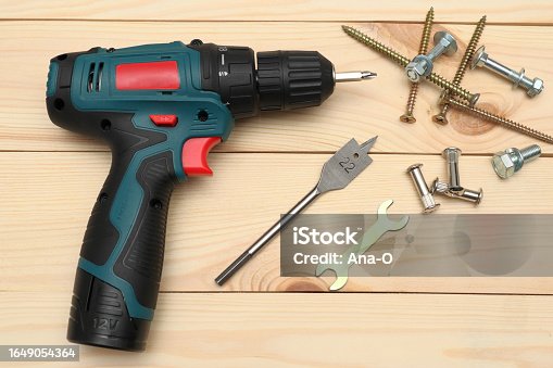 istock set of tools on wooden table, a electric screwdriver with a set of drill bits and screws with bolts. work tool on wooden background. Hand tool closeup 1649054364