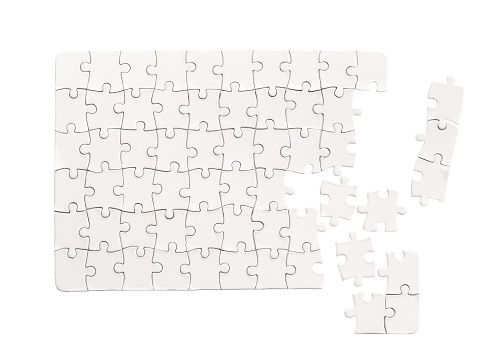 Three puzzle pieces are pieced together to form a whole, seen aerially against the background of a rustic wooden table.