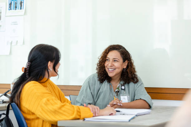 College professor tutors student after class stock photo