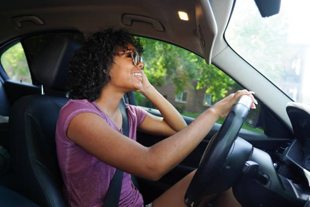 istock Young woman looking in the mirror while driving 1649081007